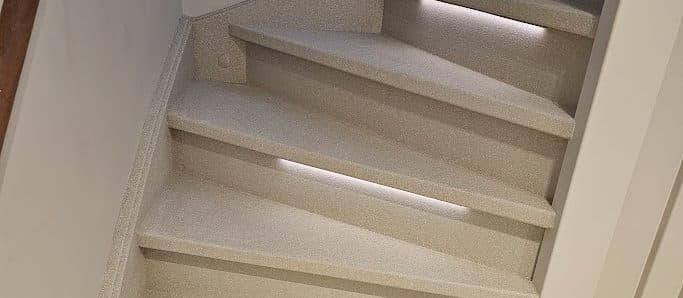 Finished staircase by Creastairs in warm beige Terrazzo composite with integrated LED lighting — seamless, wear-resistant, installed using the Omnistair EverStep system