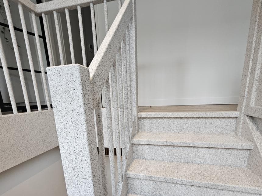 Final result by Creastairs — full staircase finish including stringers, posts and treads in light mottled Stone composite